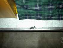 Floor mounted snuging lock slide for hatch lock