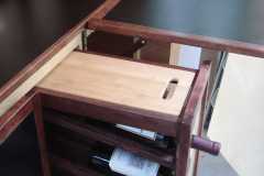 Removeable cutting board on top of wine rack. Wine rack can also be used to store canned goods